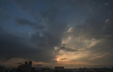 乌云密布的城市上空透出暖阳