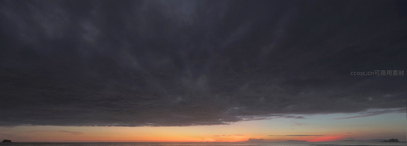 海平面上空乌云密布的日落奇观
