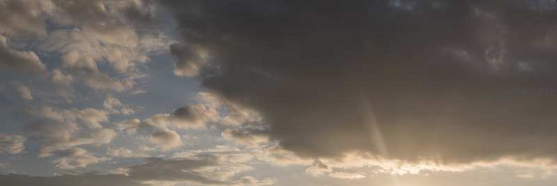 夕阳穿透厚重云层洒下金色光芒