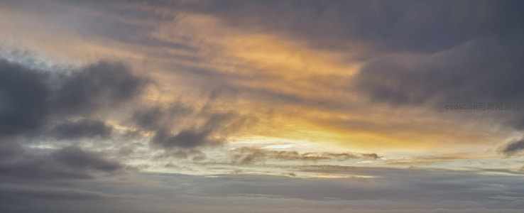 浓云裂隙透金光，夕阳余晖洒人间