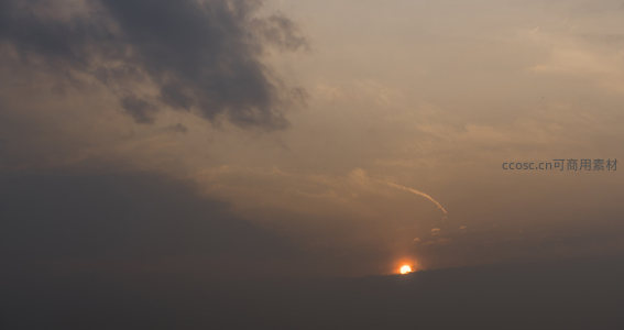 夕阳西下，云层间透出金色光芒