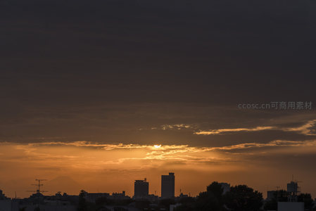 城市剪影与云层间透出的金色阳光