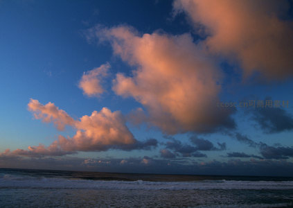 金色云朵漂浮于深蓝海岸线