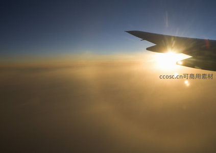 飞机舷窗视角，机翼剪影映衬日落余晖