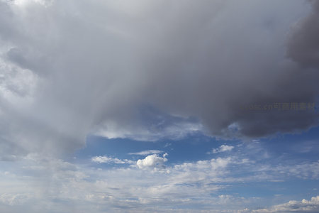 巨大灰云笼罩下的晴朗蓝天一角