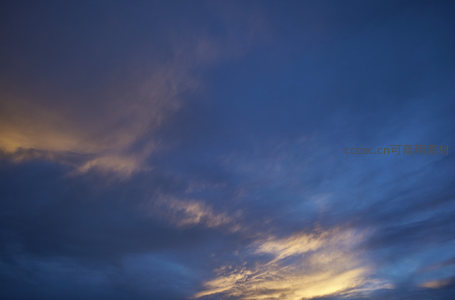 深蓝夜幕初垂，云隙透金光点点