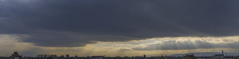 都市全景，乌云笼罩下的金色曙光