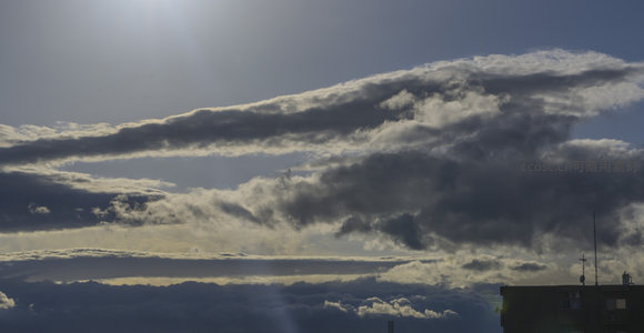 城市上空乌云密布，阳光艰难穿透