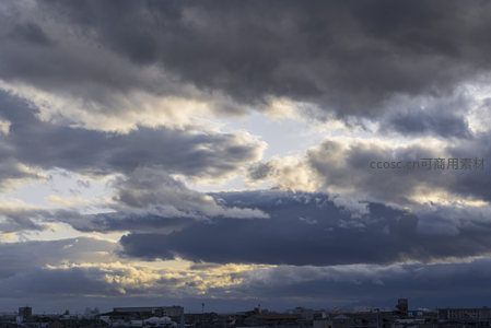 城市上空厚重云层与夕阳余晖交织
