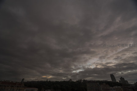 城市上空厚重乌云笼罩，天色阴沉欲雨