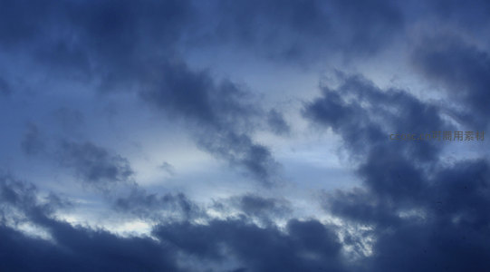 深蓝暮色云层翻涌，天际线隐现微光