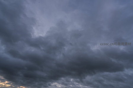 乌云密布压顶，黄昏余晖穿透云隙