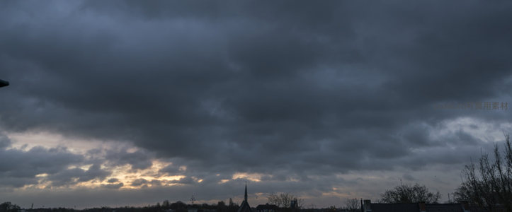 乌云压城日落时分，城市剪影静谧
