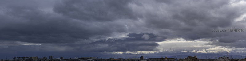 城市上空乌云压顶，楼宇在风暴前静默伫立。