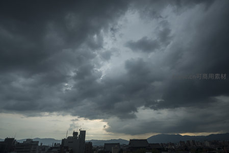 城市上空的阴云密布，山峦隐约可见