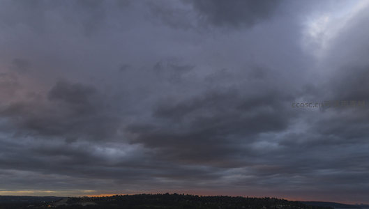 城市上空低垂的云层，黄昏时分的宁静景象