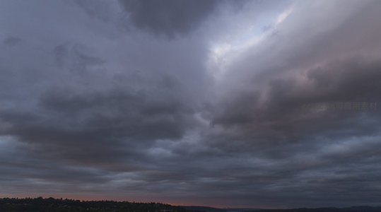 城市上空阴云压境，黄昏余晖隐现