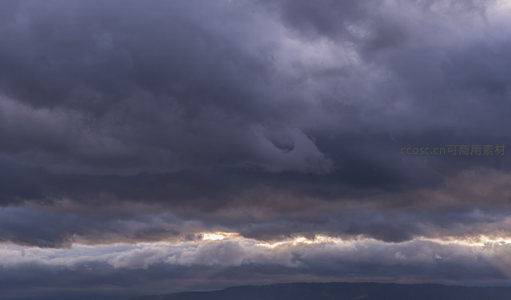 乌云密布天际线，霞光穿透云层缝隙