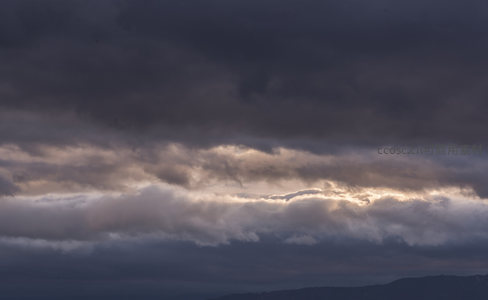 暮色苍穹云海涌，金边勾勒暗云层