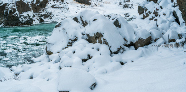 雪覆巨石静卧河畔