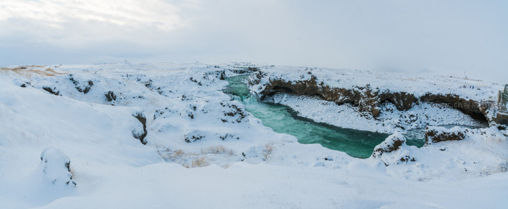 广角雪原，蜿蜒碧河穿越无垠白色世界