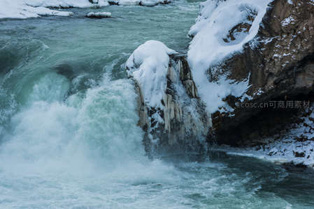 雪覆岩壁激流飞溅的冬日峡谷