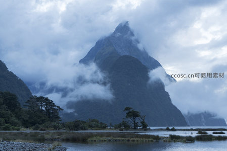 云海中的尖峰山峦与湖岸森林
