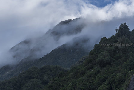 云雾轻抚山脊，深林隐现幽径