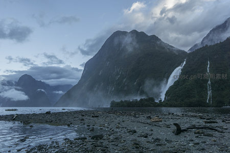 瀑布从翠绿山崖倾泻入幽深峡湾