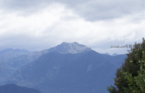 远山峰顶破云而出，巍峨挺立