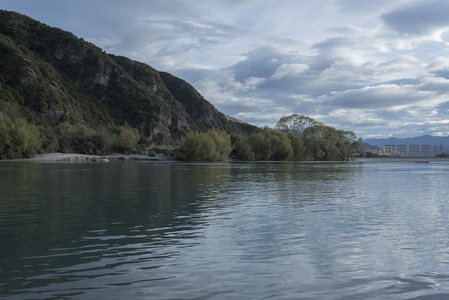 山峦环抱的宁静河湾，云影倒映水面