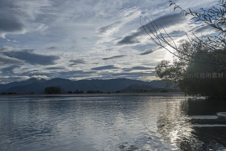 湖面如镜映山峦，枝叶轻拂水天间