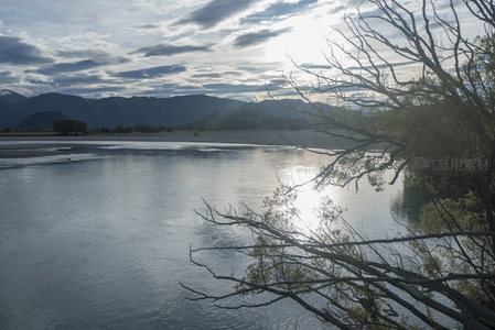 枯枝斜伸河面，远山如黛云卷云舒