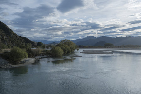 宽阔河谷穿山而过，沙洲绿岛点缀其间