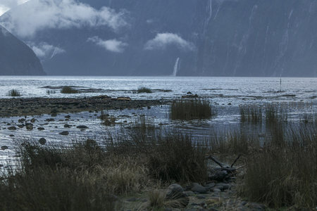 雨雾中的峡湾秘境，瀑布如丝带垂落山崖