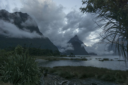 云雾缭绕的峡湾山景，静谧湖水映衬苍翠峰峦