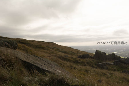 岩石与枯草覆盖的山顶俯瞰城市