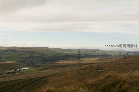 风车点缀的连绵山丘与输电塔