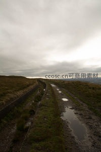 湿滑土路蜿蜒于荒芜山脊之上