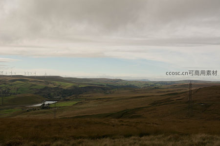 广阔山谷中的风车群与输电塔