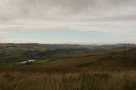 风车点缀的丘陵风光，云层低垂