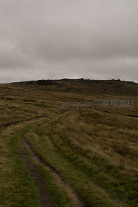 蜿蜒泥路通向荒野山丘