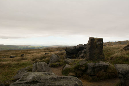 古老石碑矗立在荒草覆盖的山坡
