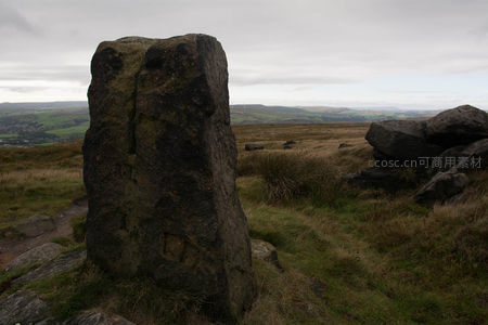 高耸石碑近景与背景田野风光