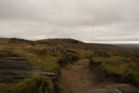 荒野小径通向远方山丘的宁静景象