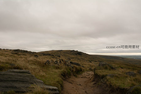 阴云密布下崎岖山野的徒步路径