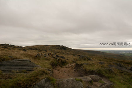 山间土路蜿蜒穿越岩石与枯草的旷野