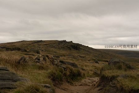 荒芜山脊下的泥泞小道与散落巨石