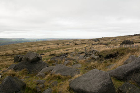 崎岖山径旁的巨石与指示路标