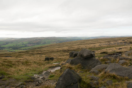 荒野巨石与远山风车的静谧风景